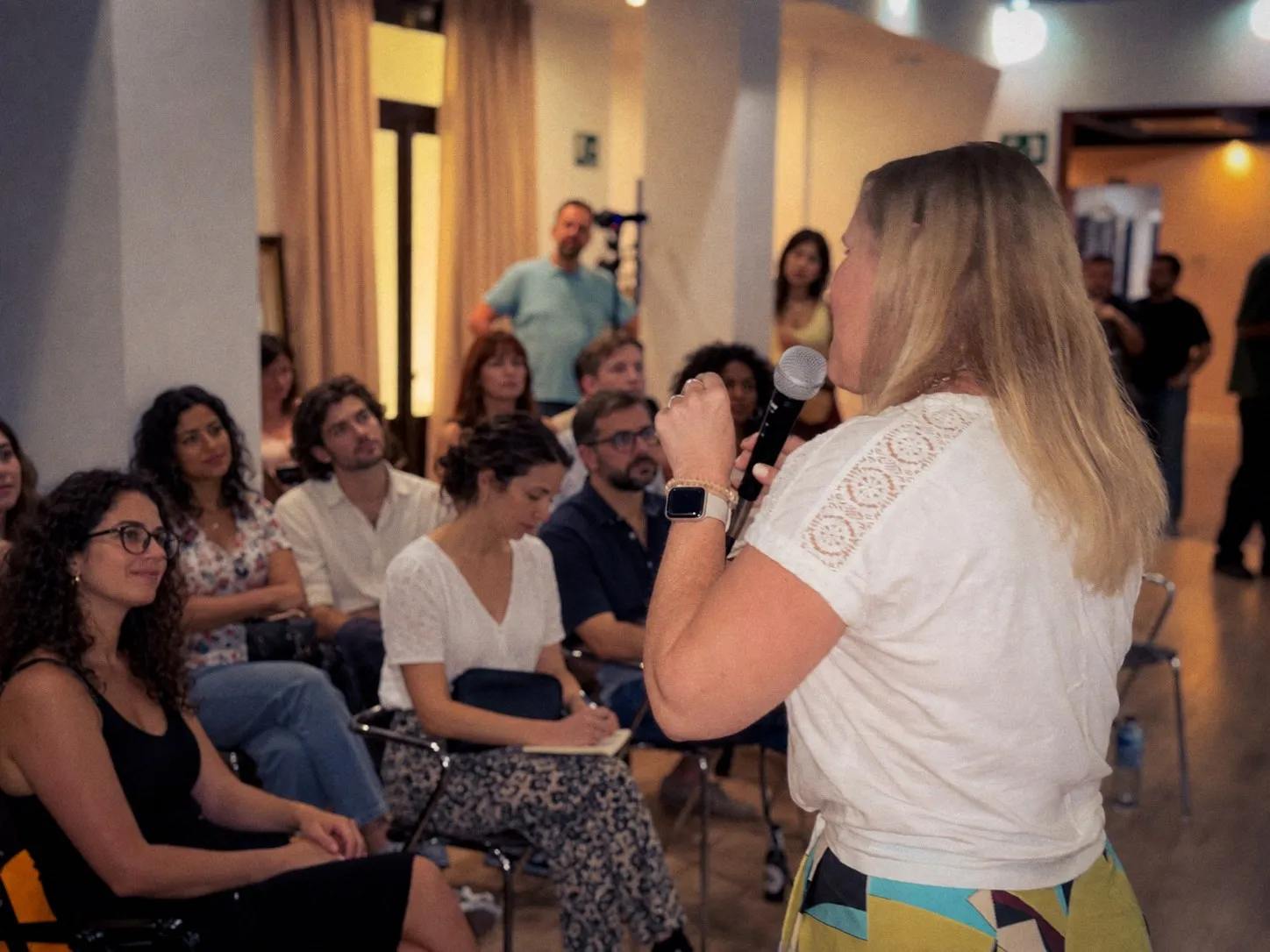Kirsten speaking to a group, one of them taking notes